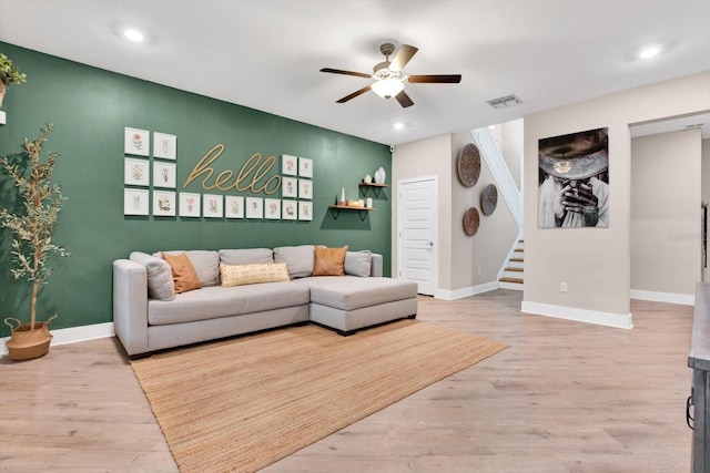 living room with ceiling fan, stairway, wood finished floors, and baseboards