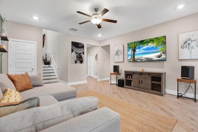 living area featuring visible vents, stairway, baseboards, and wood finished floors