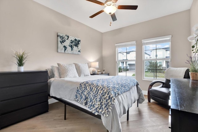 bedroom featuring light wood-style floors, ceiling fan, and baseboards