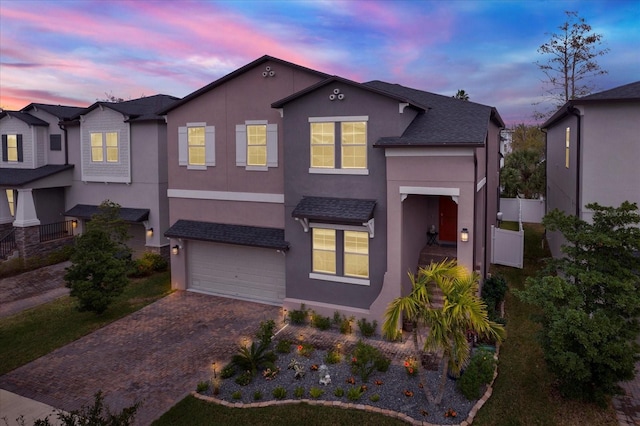 view of front of home featuring a garage, decorative driveway, and stucco siding