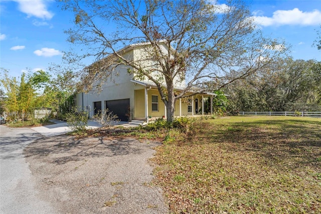 view of front of house featuring an attached garage, fence, driveway, and stucco siding