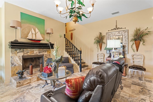 living room featuring visible vents, a notable chandelier, stone finish flooring, a stone fireplace, and stairs