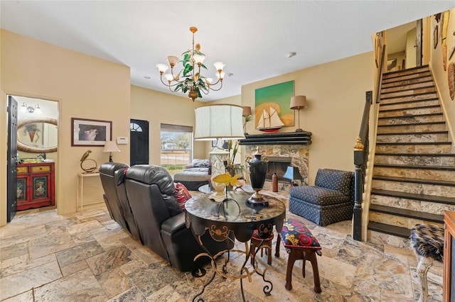 living room featuring stone tile flooring, a chandelier, a fireplace, and stairs