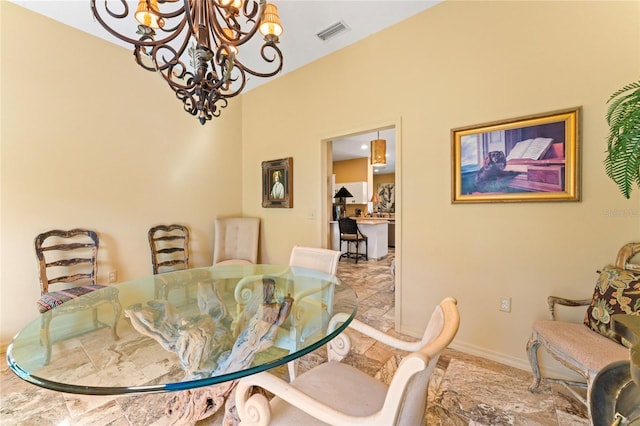 dining area with a chandelier, visible vents, and baseboards