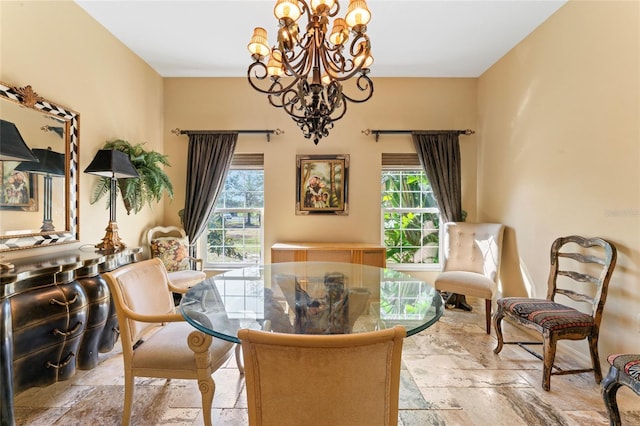 dining area featuring stone tile floors and a chandelier