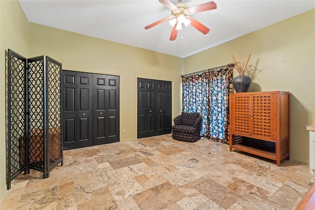 sitting room featuring stone finish flooring and ceiling fan