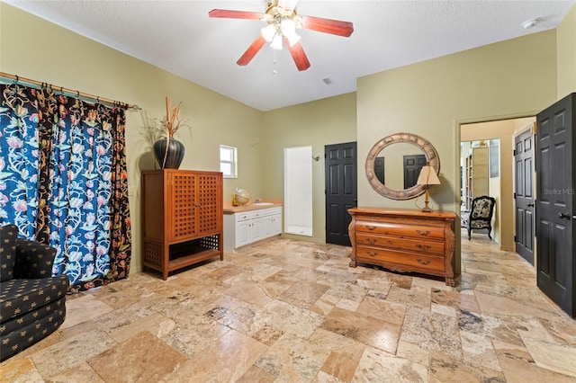 bedroom with stone tile flooring, a textured ceiling, and ceiling fan