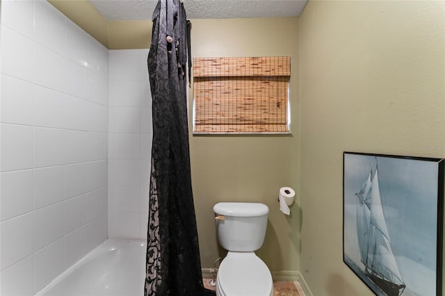 bathroom featuring shower / bath combination with curtain, toilet, a textured ceiling, and baseboards