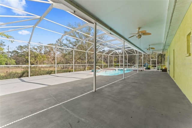 view of patio with an outdoor pool, glass enclosure, and a ceiling fan