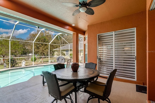 view of patio featuring visible vents, a ceiling fan, glass enclosure, and an outdoor pool