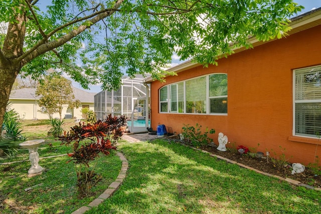 view of yard with glass enclosure and an outdoor pool