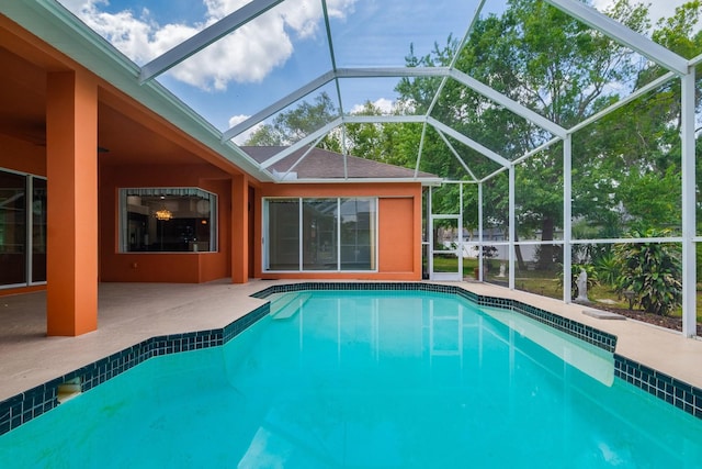 pool with a patio and glass enclosure