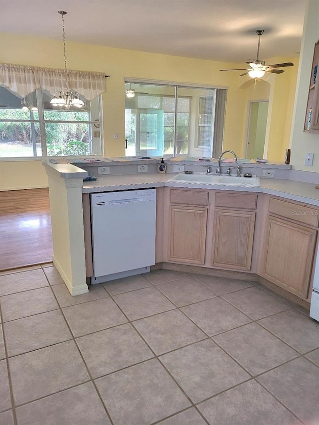 kitchen with light tile patterned floors, light brown cabinets, a sink, light countertops, and dishwasher