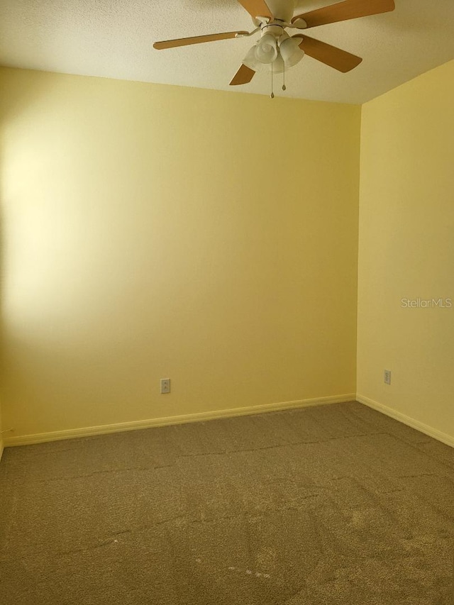 carpeted empty room with a ceiling fan, a textured ceiling, and baseboards