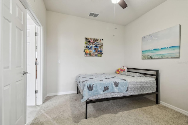 carpeted bedroom featuring a ceiling fan, visible vents, and baseboards