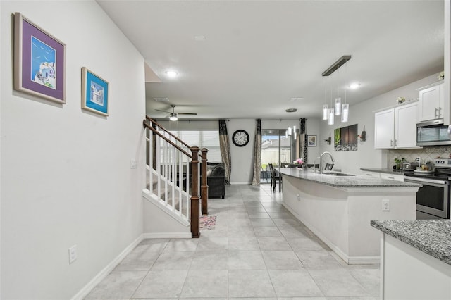 kitchen featuring light stone countertops, tasteful backsplash, a kitchen island with sink, and appliances with stainless steel finishes