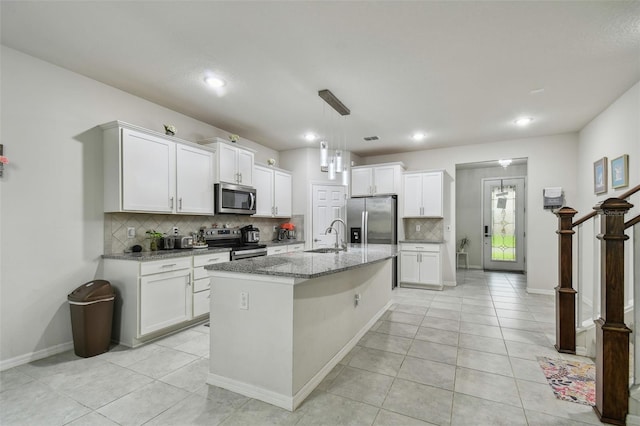 kitchen featuring light stone counters, stainless steel appliances, a sink, and light tile patterned flooring