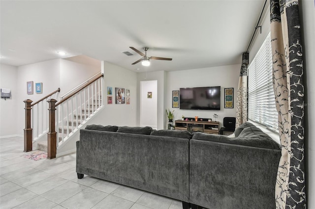 living room featuring light tile patterned floors, ceiling fan, stairs, and visible vents