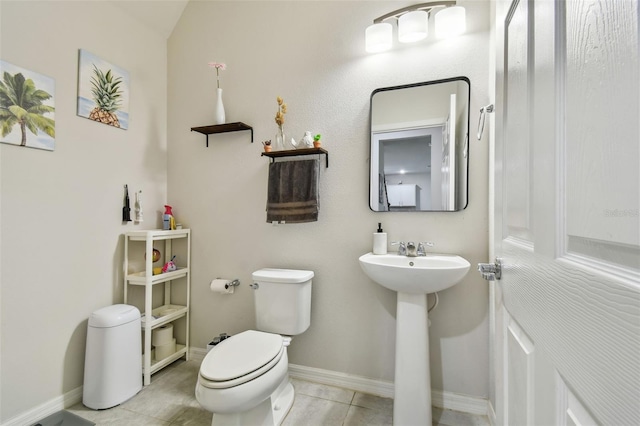 bathroom featuring tile patterned flooring, baseboards, a sink, and toilet