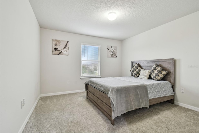 bedroom with light carpet, a textured ceiling, and baseboards