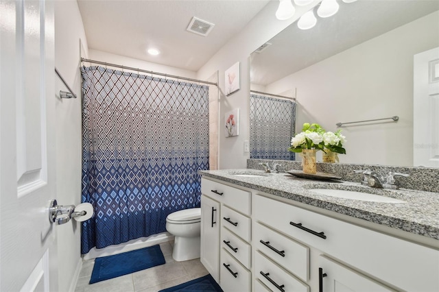 bathroom featuring tile patterned flooring, toilet, a sink, visible vents, and double vanity