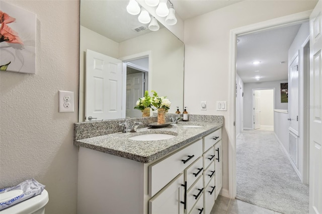 bathroom featuring visible vents, a sink, baseboards, and double vanity