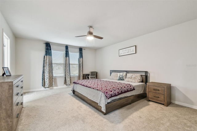 bedroom featuring light colored carpet, ceiling fan, and baseboards