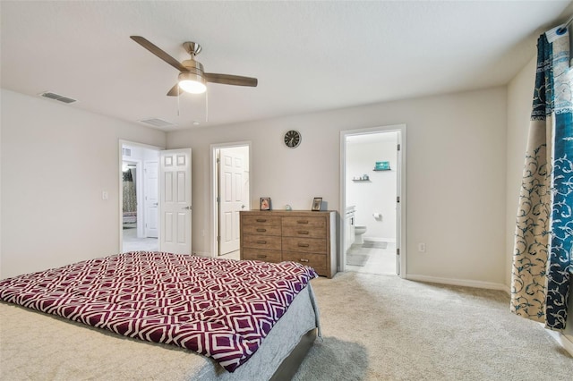 carpeted bedroom featuring ensuite bathroom, baseboards, visible vents, and a ceiling fan