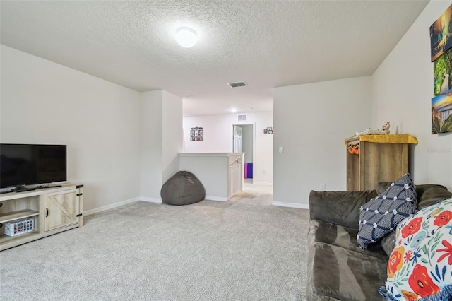 carpeted living area with visible vents, a textured ceiling, and baseboards