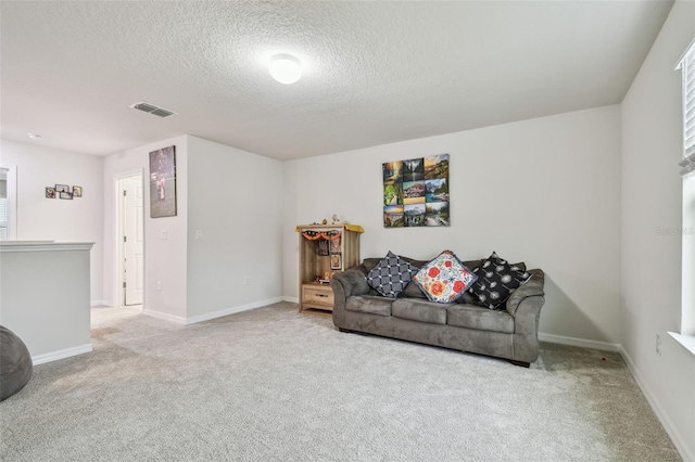 living area with carpet, a textured ceiling, visible vents, and baseboards