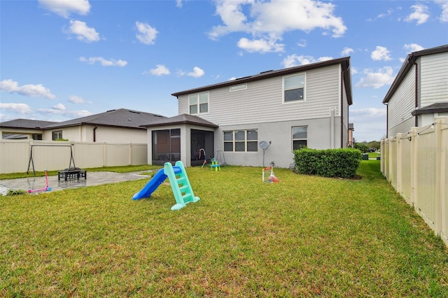 back of house with a patio, a lawn, a fenced backyard, and a sunroom