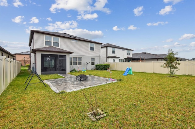 rear view of property with a lawn, a patio area, a fenced backyard, and a sunroom