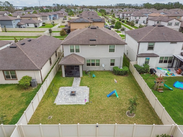 exterior space featuring a patio, central AC unit, a fenced backyard, a residential view, and a front yard