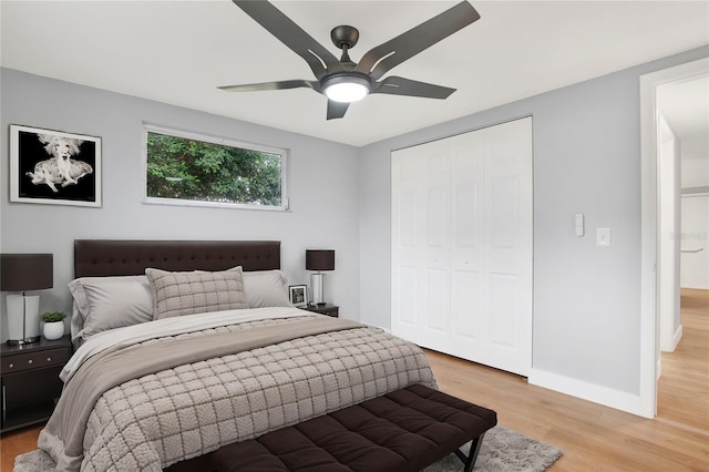 bedroom with light wood-type flooring, a closet, ceiling fan, and baseboards