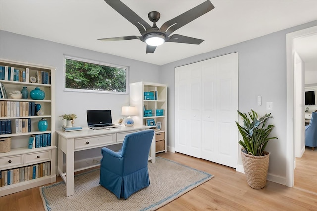 home office with light wood-style flooring, baseboards, and a ceiling fan