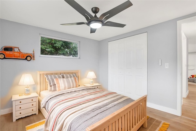 bedroom with a ceiling fan, a closet, baseboards, and light wood finished floors