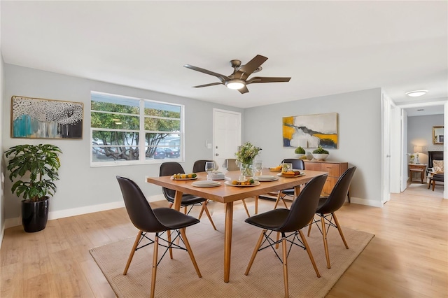 dining area featuring light wood-style floors, ceiling fan, and baseboards