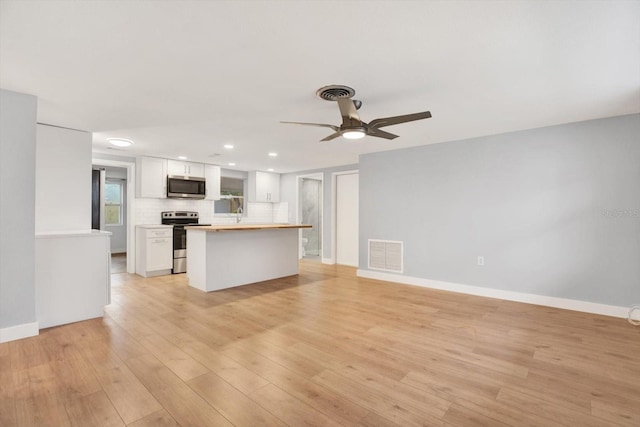 interior space featuring light wood finished floors, recessed lighting, visible vents, ceiling fan, and baseboards