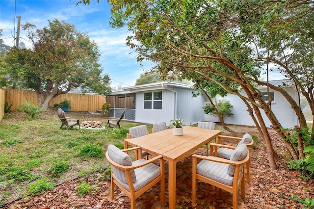 view of yard featuring a fenced backyard, a fire pit, and outdoor dining space