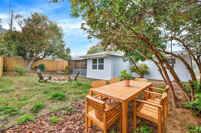 view of yard featuring a fire pit, outdoor dining area, and a fenced backyard