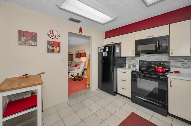 kitchen featuring visible vents, white cabinets, decorative backsplash, light countertops, and black appliances