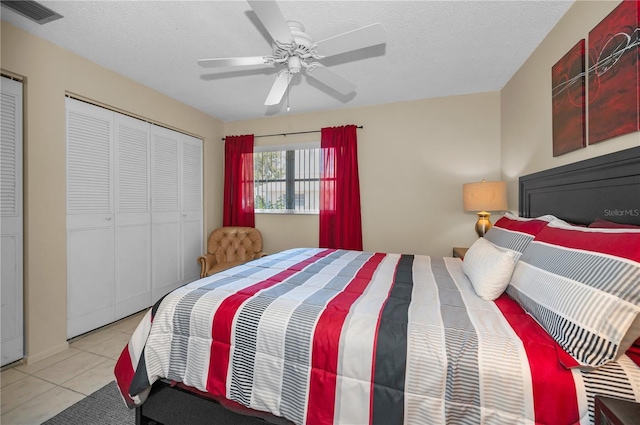 bedroom with light tile patterned floors, ceiling fan, visible vents, and a textured ceiling