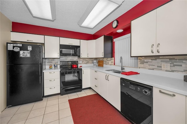 kitchen with black appliances, light tile patterned floors, white cabinetry, and light countertops