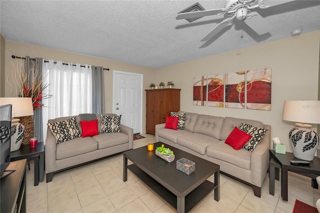 living area with ceiling fan, a textured ceiling, and light tile patterned floors