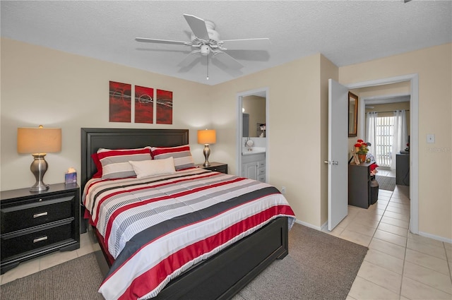 bedroom with baseboards, ceiling fan, ensuite bathroom, tile patterned flooring, and a textured ceiling