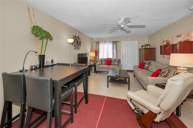 living room featuring a ceiling fan, a textured ceiling, and light tile patterned flooring