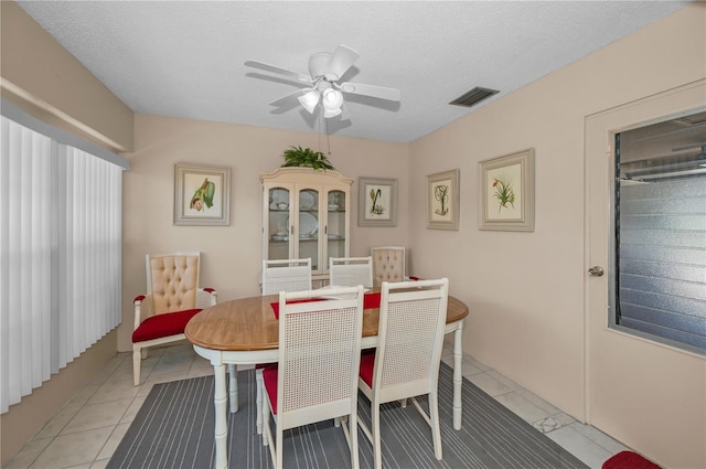 dining room with visible vents, ceiling fan, a textured ceiling, and light tile patterned floors