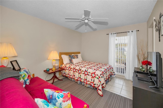 tiled bedroom with a textured ceiling and ceiling fan