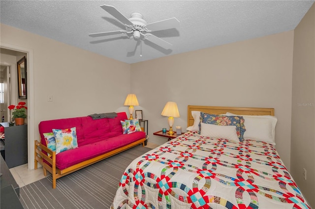 bedroom with ceiling fan and a textured ceiling