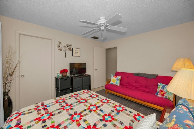 bedroom featuring a textured ceiling, ceiling fan, and visible vents